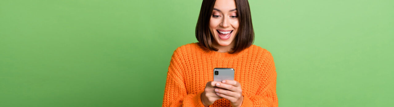 Woman looking at phone excitedly