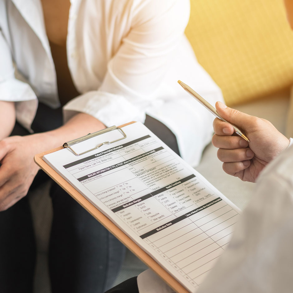 Doctor with clipboard talking to patient