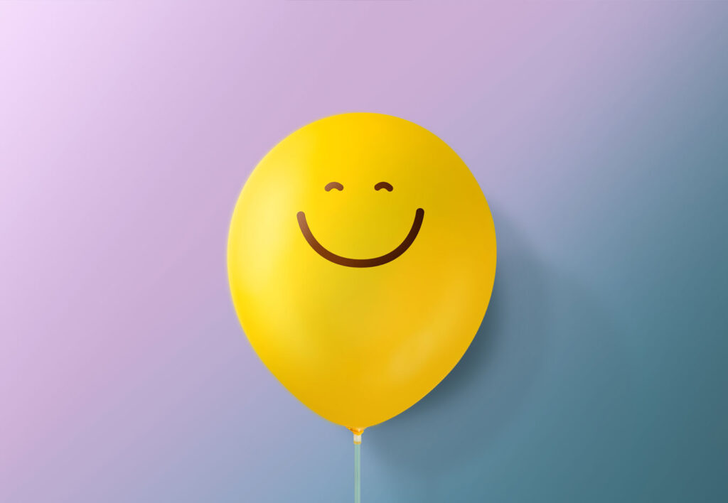 yellow balloon floating with a smiley face