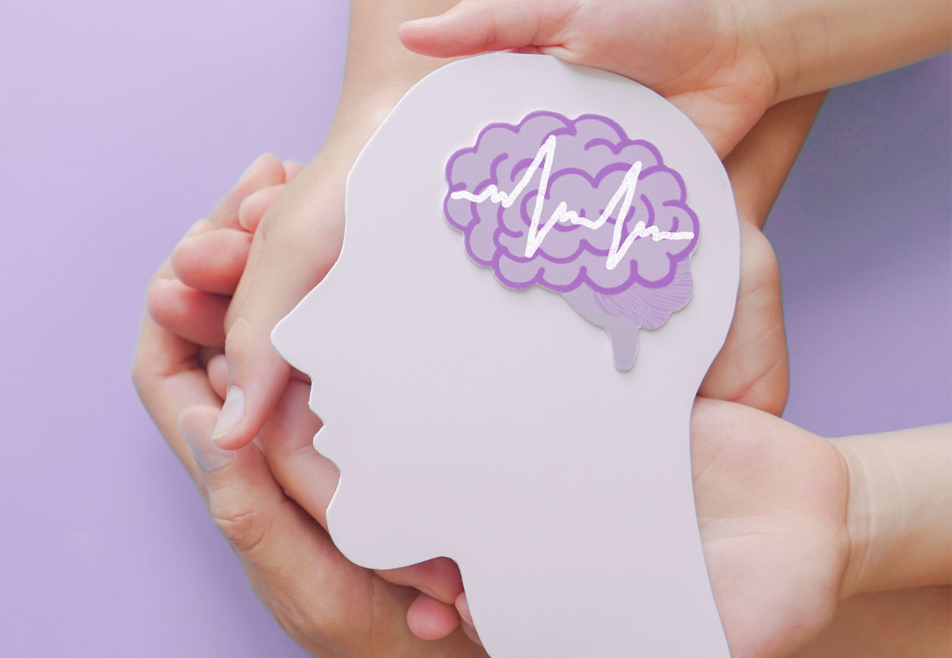 Three hands support a head with it's brain shown